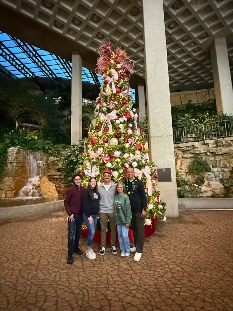 Garrett with his family beside a Christmas tree