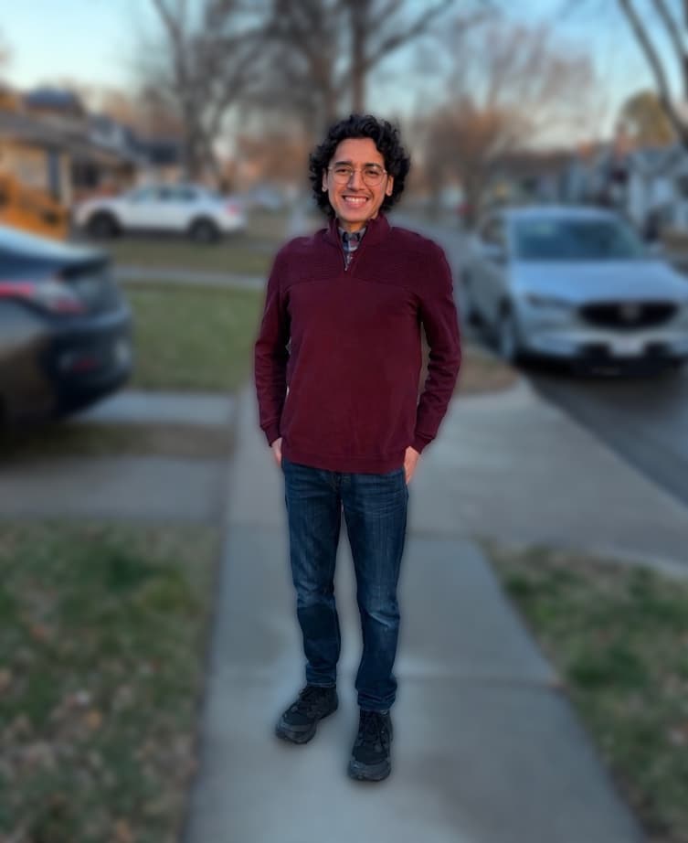 Garrett, smiling on a sidewalk in his neighborhood